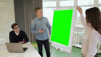 Man and woman show something on flipchart video