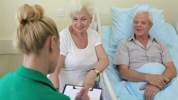 Nurse notes the state of health of senior male patient video