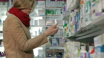 Female customer takes ointment from shelf at the drugstore video