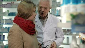 Male druggist consultates female customer at the drugstore video
