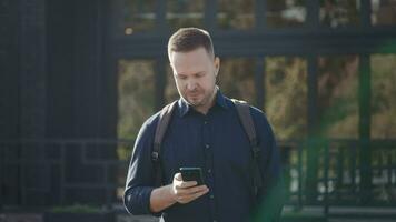 Modern urban man uses a smartphone on a city street. Internet technologies make it easier to access various services and assistants using mobile applications. video