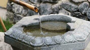 Close up shot of purification fountain with bamboo and stone basin in Japan video