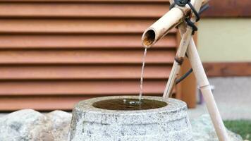 Close up shot of purification fountain with bamboo and stone basin in Japan video