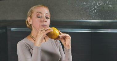 A girl with blue eyes and a turtleneck eats a big juicy pear video