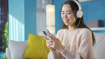 aantrekkelijk vrolijk Aziatisch vrouw luisteren naar muziek. video