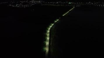 aéreo Visão do uma deserta rua às noite. aéreo Visão do uma linha do rua luzes em a Beira do lago limboto, gorontalo-indonesia video