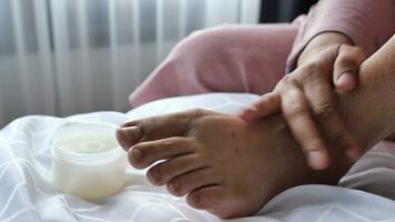 woman applying petroleum jelly on feet at home close up. video