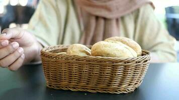 women hand pick bread bun on table video