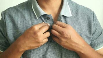 Man buttoning his shirt close up video