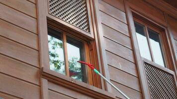 Rubber squeegee cleans a soaped window. video
