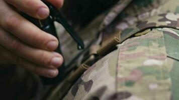 une soldat bloque une talkie walkie sur le sien uniforme video