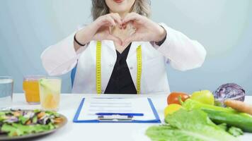 nutricionista dietético médico hace corazón en cámara. sano estilo de vida. video