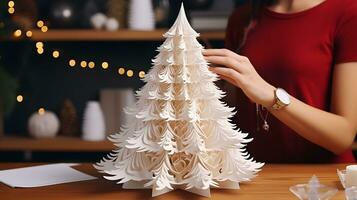Woman assembling white paper Christmas tree photo