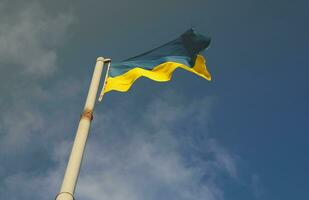 Ukraine flag large national symbol fluttering in blue sky. Large yellow blue Ukrainian state flag, Dnipro city, Independence Constitution Day photo