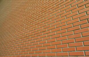 The texture of a high brick wall from a many rows of red bricks stretching into perspective photo