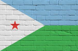 Djibouti flag depicted in paint colors on old brick wall. Textured banner on big brick wall masonry background photo