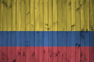 Colombia bandera representado en brillante pintar colores en antiguo de madera pared. texturizado bandera en áspero antecedentes foto