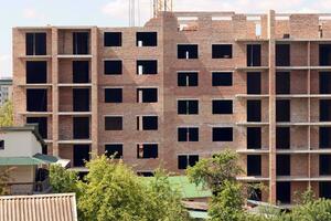 View of a large construction site with buildings under construction and multi-storey residential homes. Housing renovation photo