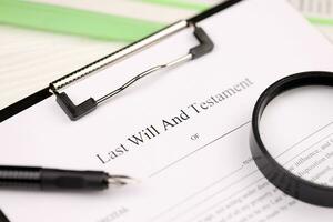 Last Will and testament blank document on A4 tablet lies on office table with pen and magnifying glass photo
