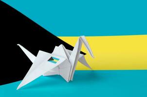 Bahamas flag depicted on paper origami crane wing. Handmade arts concept photo