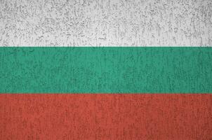 Bulgaria flag depicted in bright paint colors on old relief plastering wall. Textured banner on rough background photo