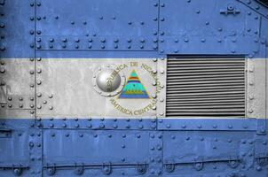 Nicaragua flag depicted on side part of military armored tank closeup. Army forces conceptual background photo