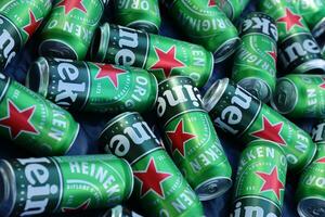 KHARKOV, UKRAINE - JULY 31, 2021 Green tin cans of Heineken lager beer produced by the Dutch brewing company Heineken N.V. photo