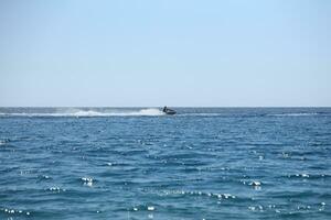 ANTALYA, TURKEY - MAY 15, 2021 Young Man on water scooter drive on waves in mediterranean photo