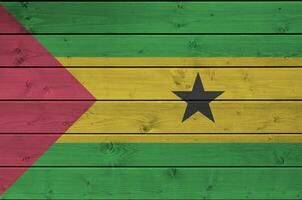 Sao Tome and Principe flag depicted in bright paint colors on old wooden wall. Textured banner on rough background photo