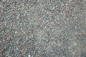 Close up of muddy puddle with small stones on wet surface. Background texture with top view photo