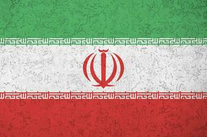 Iran flag depicted in bright paint colors on old relief plastering wall. Textured banner on rough background photo