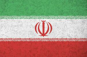 Iran flag depicted in bright paint colors on old relief plastering wall. Textured banner on rough background photo