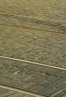 Metal tram rails in the middle of the road, laid out of a smooth paving stone photo
