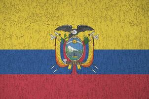 Ecuador flag depicted in bright paint colors on old relief plastering wall. Textured banner on rough background photo