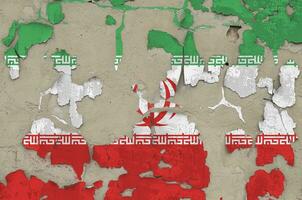 Iran flag depicted in paint colors on old obsolete messy concrete wall closeup. Textured banner on rough background photo