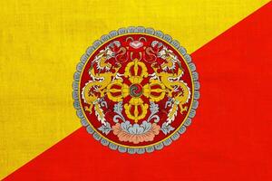 Flag and coat of arms of Kingdom of Bhutan on a textured background. Concept collage. photo