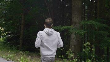 Athlete man is jogging in the forest. video