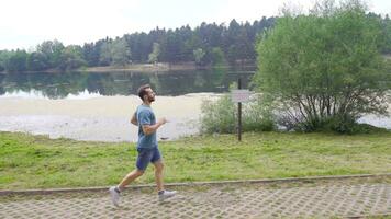 athlétique homme le jogging par le lac. video