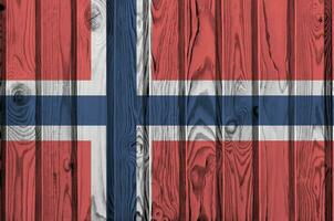 Noruega bandera representado en brillante pintar colores en antiguo de madera pared. texturizado bandera en áspero antecedentes foto