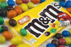 KHARKIV, UKRAINE - JANUARY 2, 2021 M and Ms colorful button shaped chocolate candies. Multi colored chocolates each of which has the letter m printed in lower case in white photo