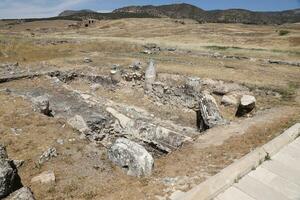 ANTALYA, TURKEY - MAY 15, 2021 Ruins of ancient city Hierapolis near Pamukkale, Turkey at sunny day. Parts of old historical buildings with big blocks photo