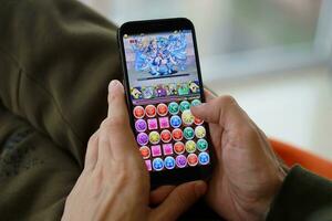 Puzzle and dragons mobile iOS game on iPhone 15 smartphone screen in male hands during mobile gameplay photo