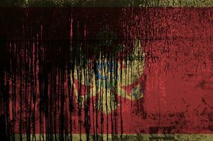 Montenegro flag depicted in paint colors on old and dirty oil barrel wall closeup. Textured banner on rough background photo