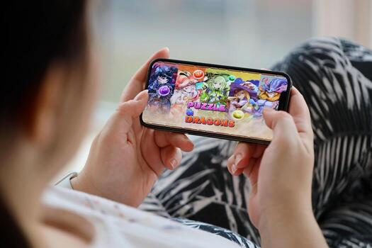 Puzzle and dragons mobile iOS game on iPhone 15 smartphone screen in female hands during mobile gameplay photo