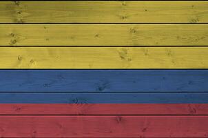 Colombia bandera representado en brillante pintar colores en antiguo de madera pared. texturizado bandera en áspero antecedentes foto