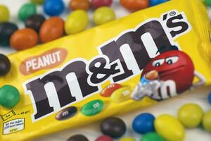 KHARKIV, UKRAINE - JANUARY 2, 2021 M and Ms colorful button shaped chocolate candies. Multi colored chocolates each of which has the letter m printed in lower case in white photo
