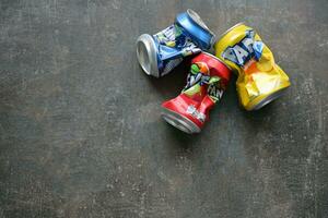 KYIV, UKRAINE - 4 MAY, 2023 Fanta soft drink brand crumpled tin cans with various flavours photo