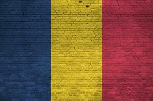 Chad flag depicted in paint colors on old brick wall. Textured banner on big brick wall masonry background photo
