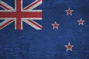 New Zealand flag depicted in paint colors on old brick wall. Textured banner on big brick wall masonry background photo