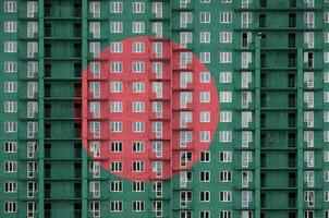 Bangladesh flag depicted in paint colors on multi-storey residental building under construction. Textured banner on brick wall background photo